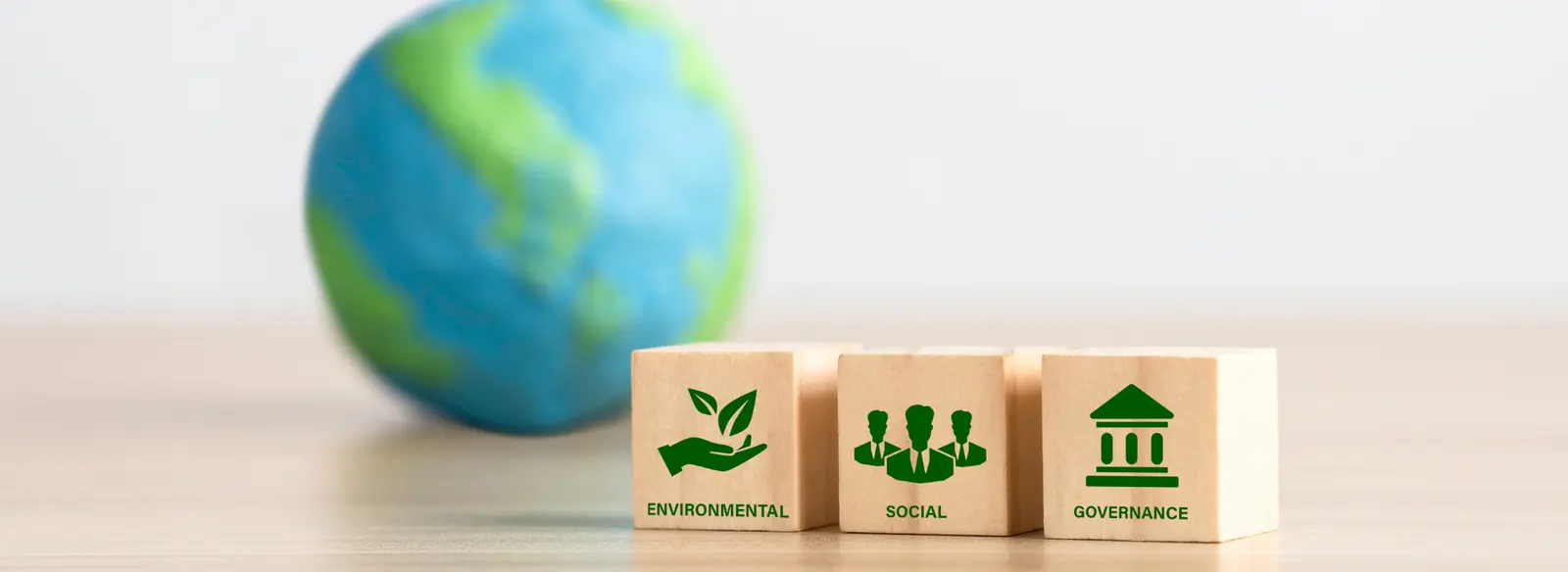 Pandomus übernimmt Verantwortung im Bereich Nachhaltigkeit. Holzwürfel mit den Symbolen für Environmental, Social und Governance.